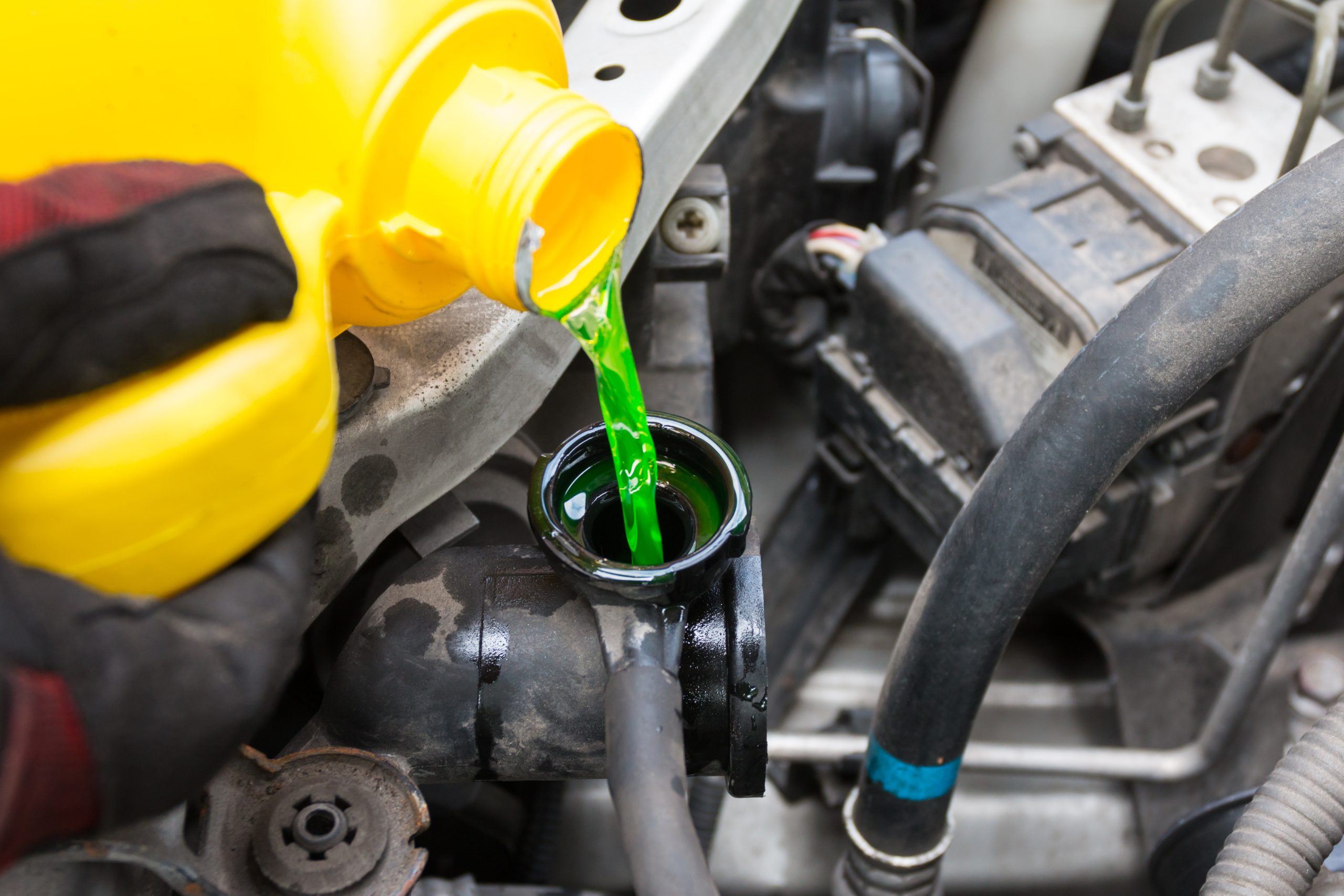 A bottle pouring coolant into a vehicle