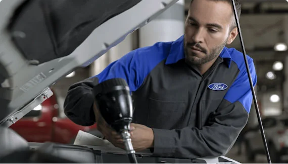 A Ford technician working on a vehicle in the shop.