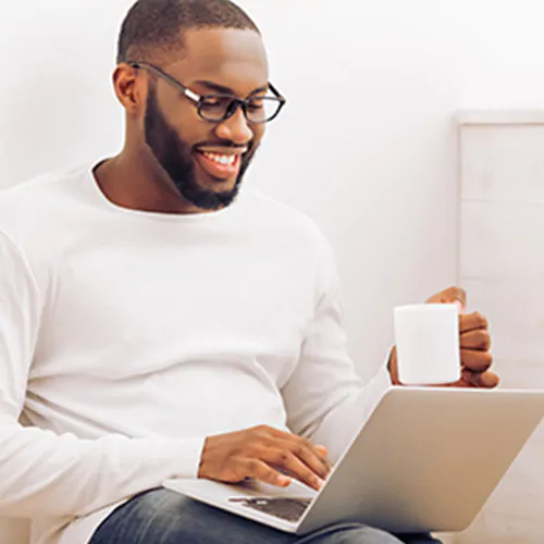 man smiling while on his laptop